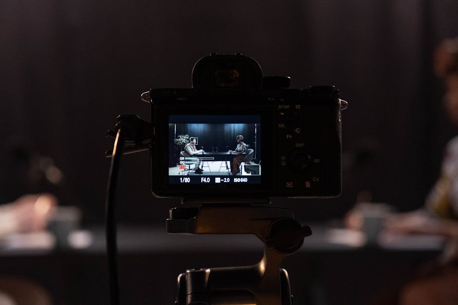 Close-up of a camera recording a podcast interview in a studio setting.