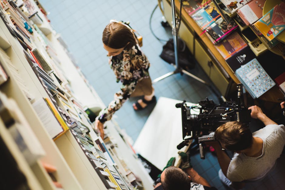 Overhead view of filming crew capturing a scene in a bookstore with camera equipment.