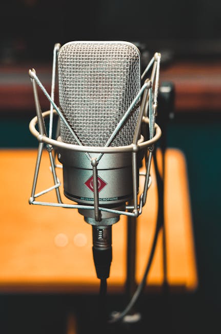 Close-up of a professional microphone on a stand, ideal for studio audio recording.